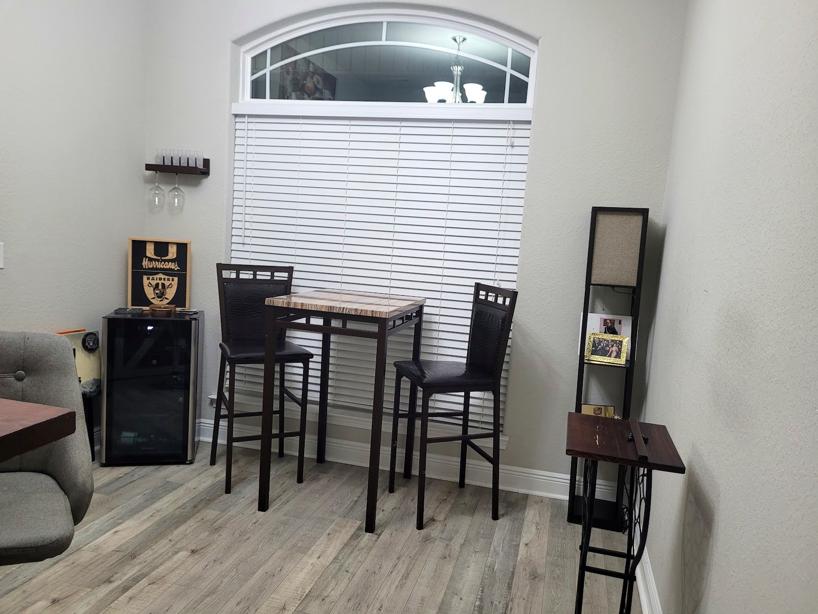 A spotless dining nook with pub table and clean plank flooring