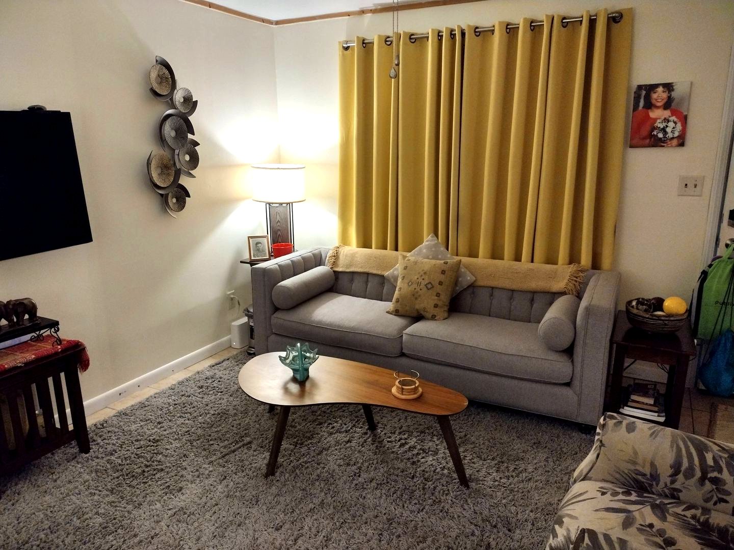 A tidy living room with a gray sofa and yellow curtains after cleaning