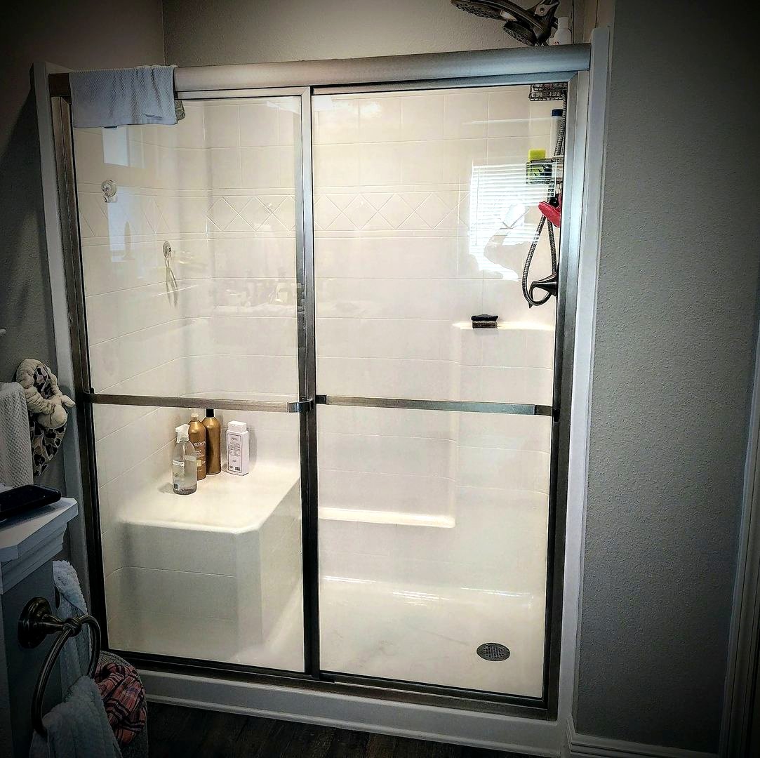 A glass shower enclosure polished until the glass nearly disappears